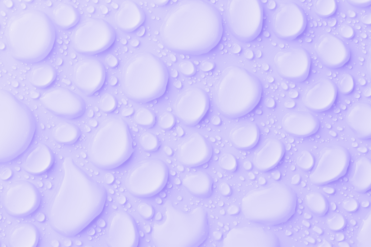 Photo représentant la formule de neutralisant d'odeurs NODO fait avec de l'eau de pluie recyclée. Gouttelettes sur fond lilas.