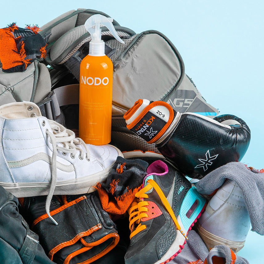 Neutralisant d’odeurs NODO pour équipement sportif, posé dans un sac rempli de souliers, gants de boxe et vêtements d’entraînement.