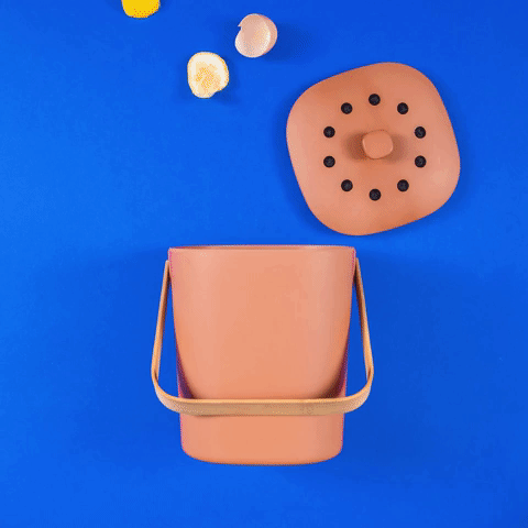 GIF d'un bac à compost dans lequel sont inséré des déchets avec une bouteille de neutralisant d'odeurs NODO