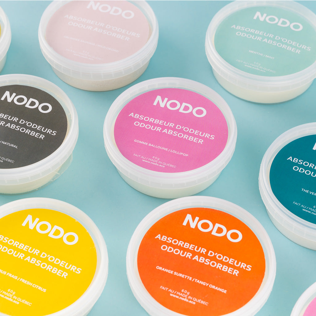 ue de dessus colorée des absorbeurs d’odeurs NODO en format 200ml, sur fond bleu pastel.