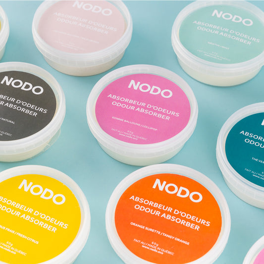 ue de dessus colorée des absorbeurs d’odeurs NODO en format 200ml, sur fond bleu pastel.